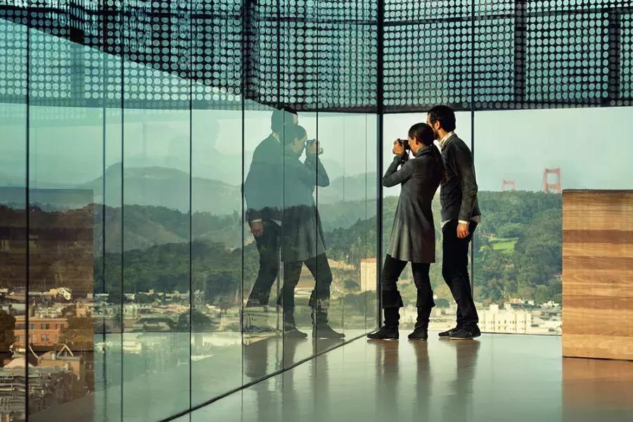 两个人透过贝博体彩app杨博物馆的玻璃墙往外看.